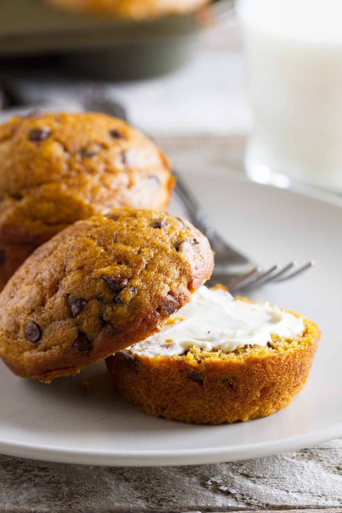 Pumpkin Chocolate Chip Muffin on a plate cut open with butter