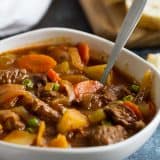 Bowl of Homemade Beef Stew with bread in the background