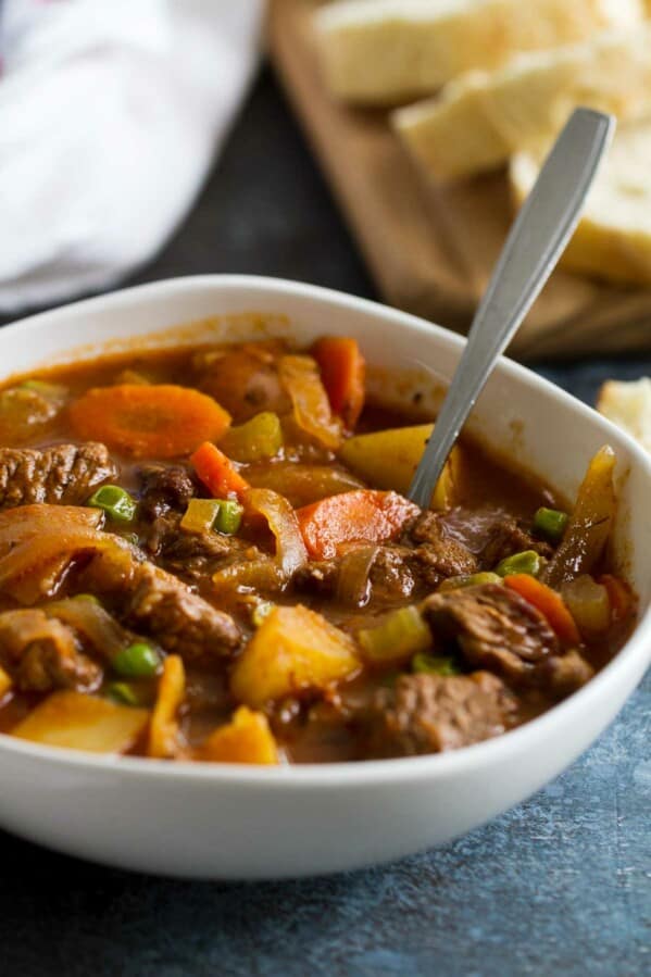 Bowl of Homemade Beef Stew with bread in the background