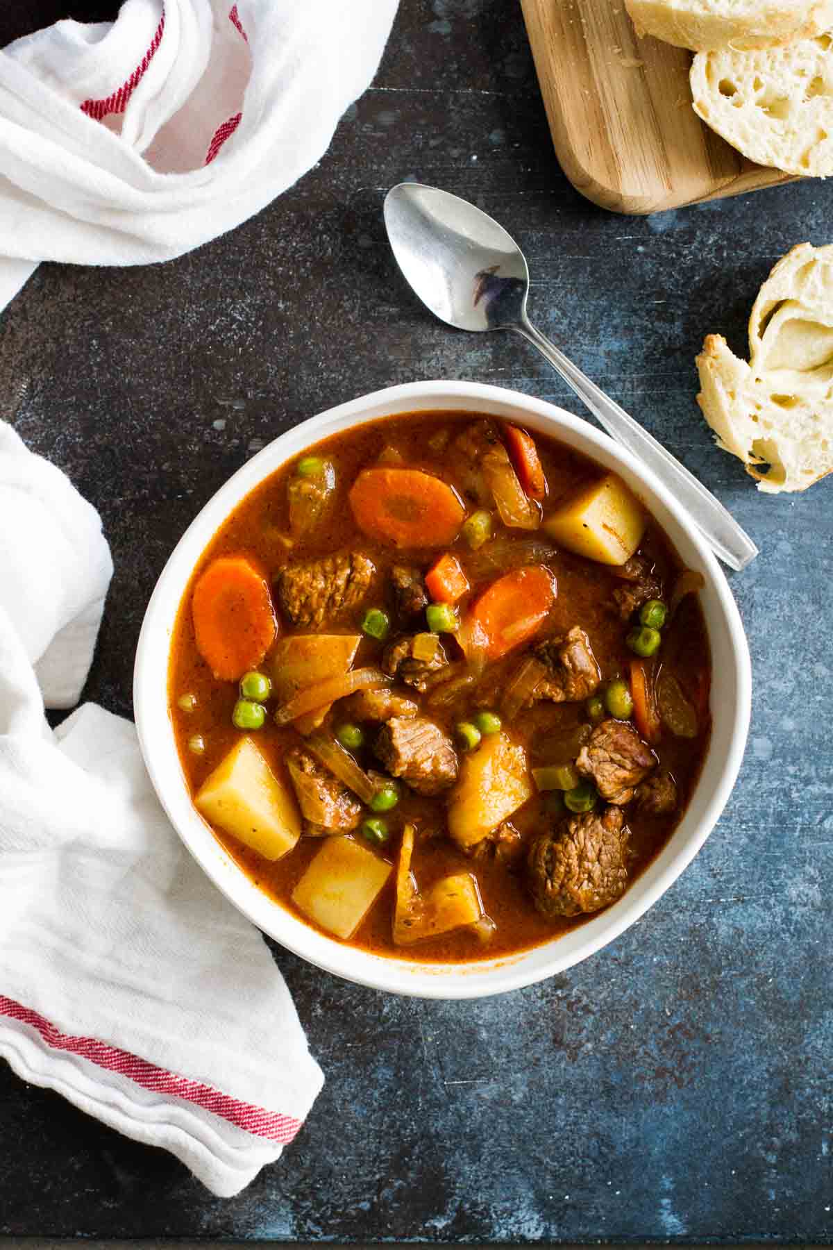 overhead view of beef stew in a bowl with a spoon