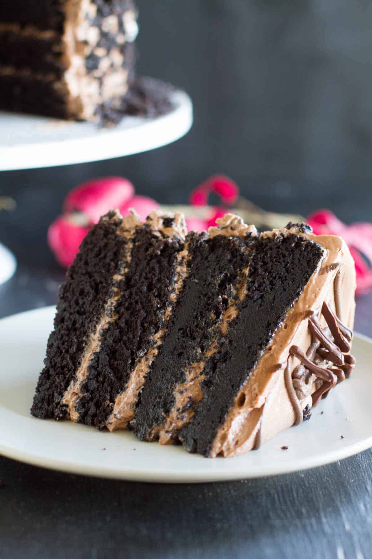 Slice of Dark Chocolate Layer Cake with Nutella Buttercream on a white plate.