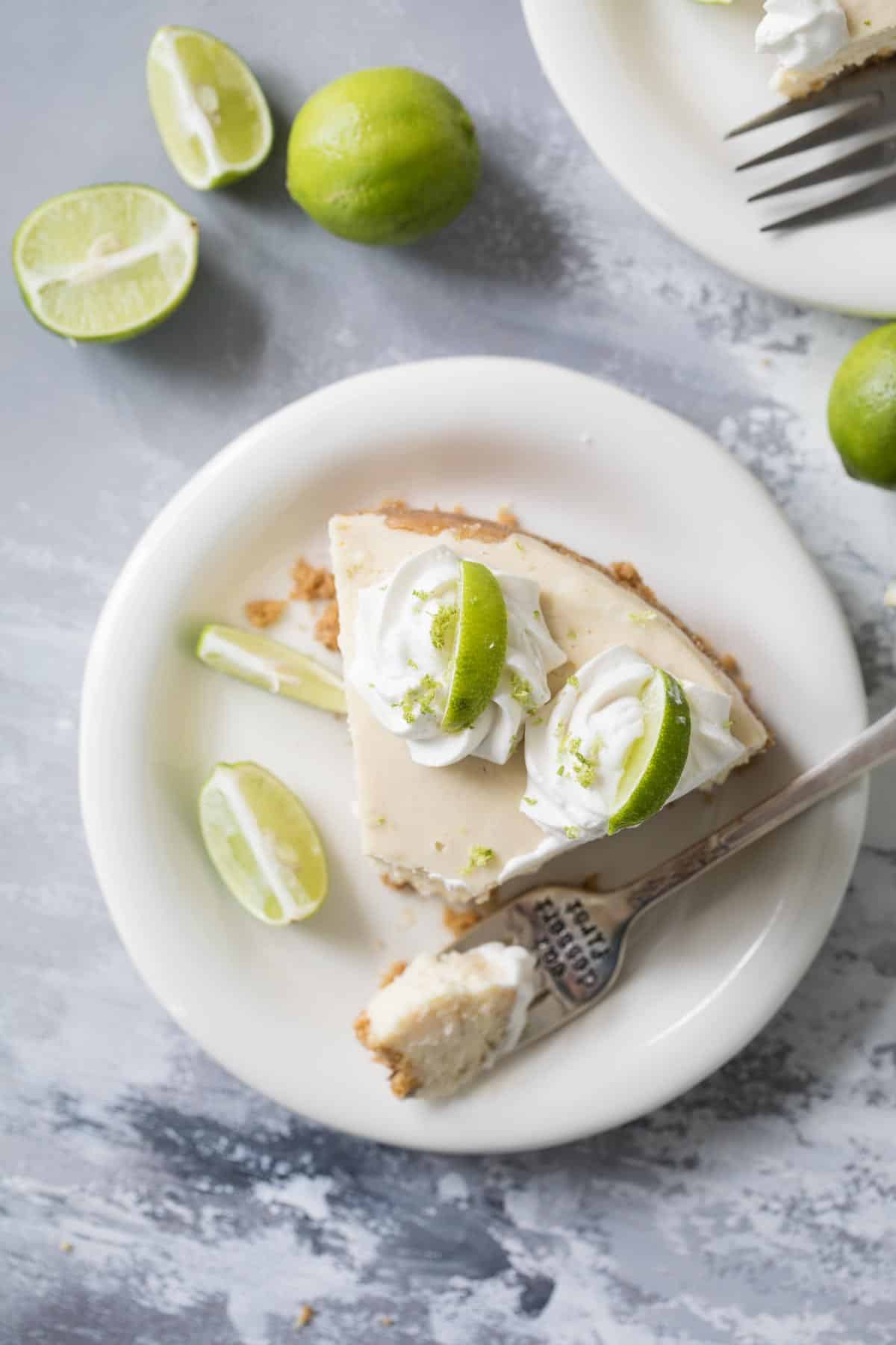 Slice of Instant Pot Key Lime Cheesecake with a fork on the plate.