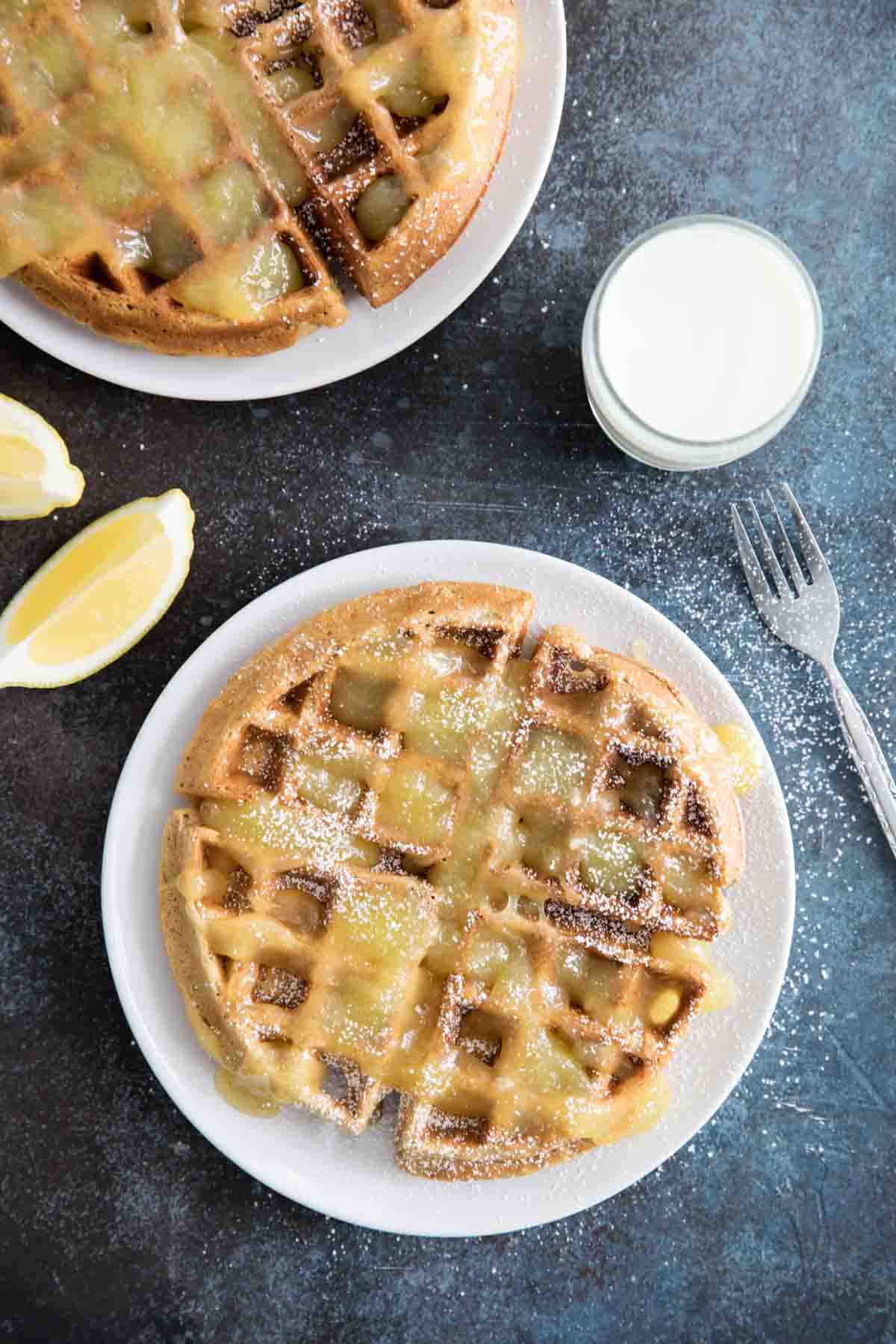 Easy Gingerbread Waffle Recipe topped with homemade lemon sauce and powdered sugar.