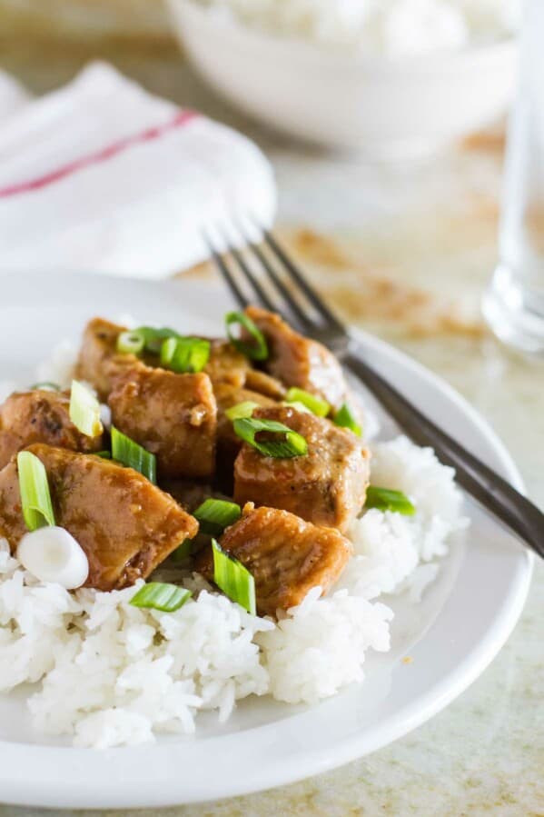 Asian Slow Cooker Pork Roast over rice on a plate.
