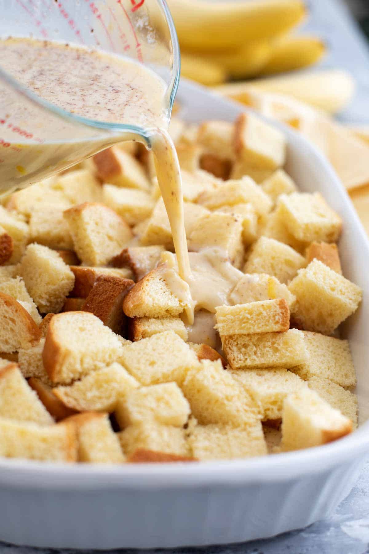 Pouring egg custard over brioche for overnight French toast.