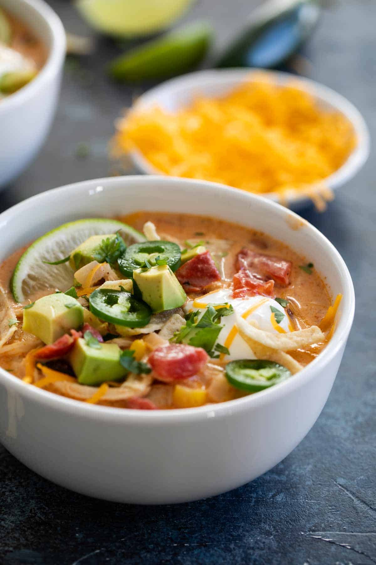 bowl of Chicken Tortilla Soup with ingredients in the background