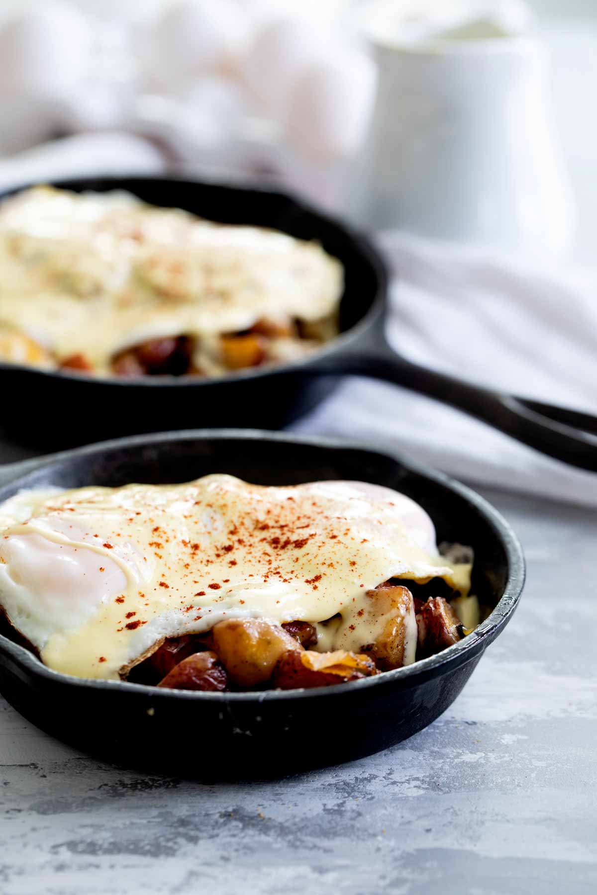 Meat and potatoes in a skillet topped with an over easy egg.