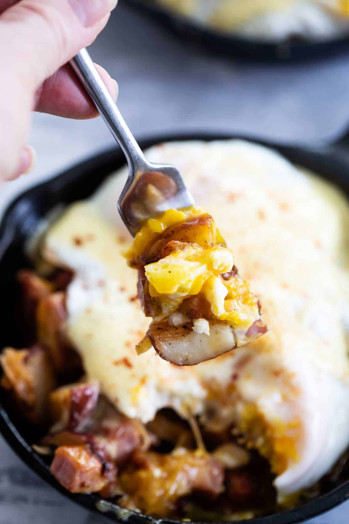 Taking a bite of Meat and Potatoes Breakfast Skillet.
