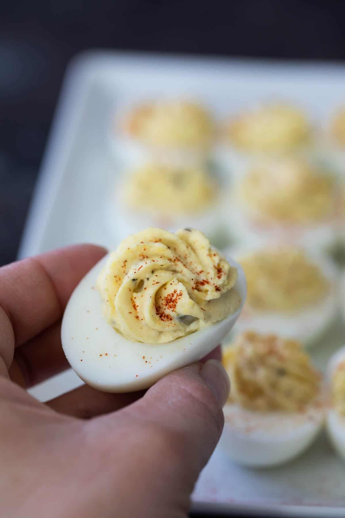 holding a single deviled egg in a hand