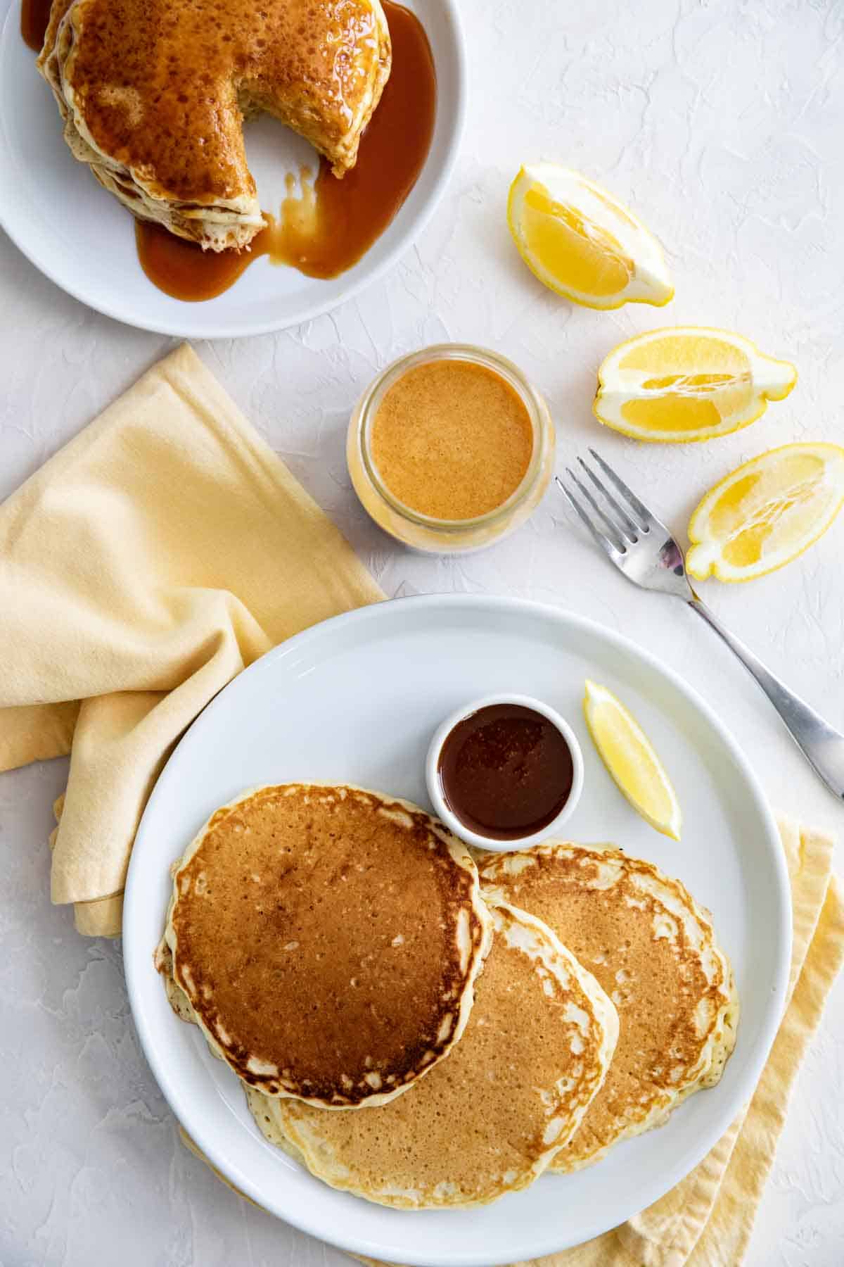 Lemon Pancakes on plates with homemade buttermilk syrup