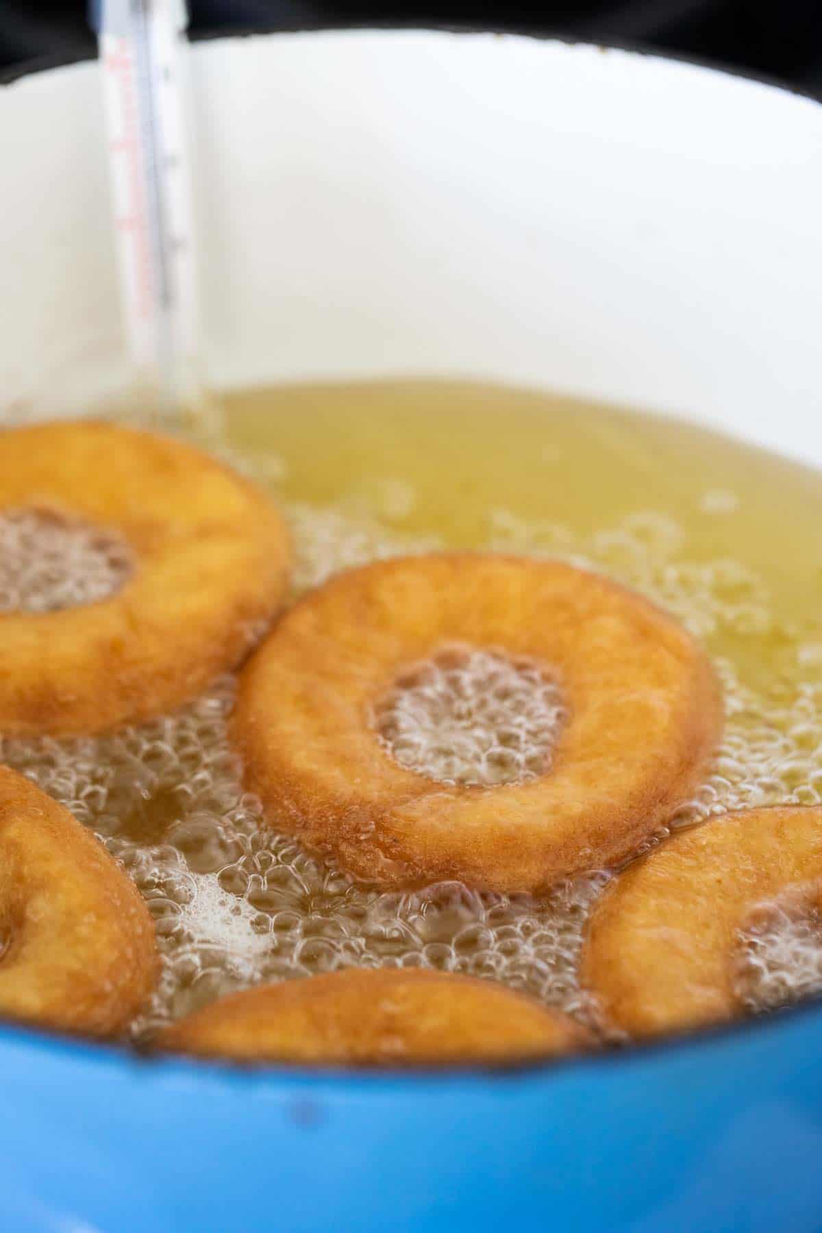 Frying cake donuts in hot oil.