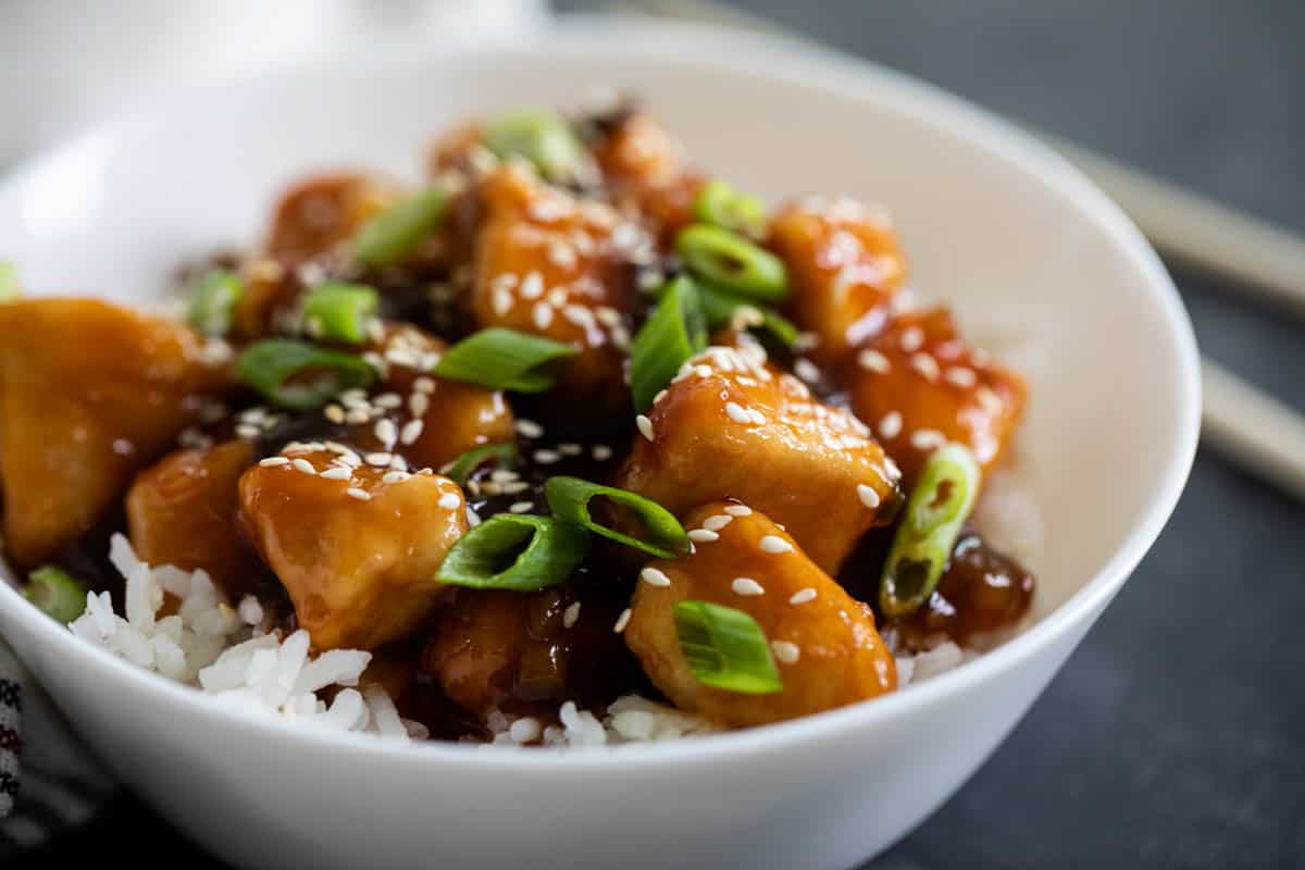 white bowl with general tso chicken and white rice