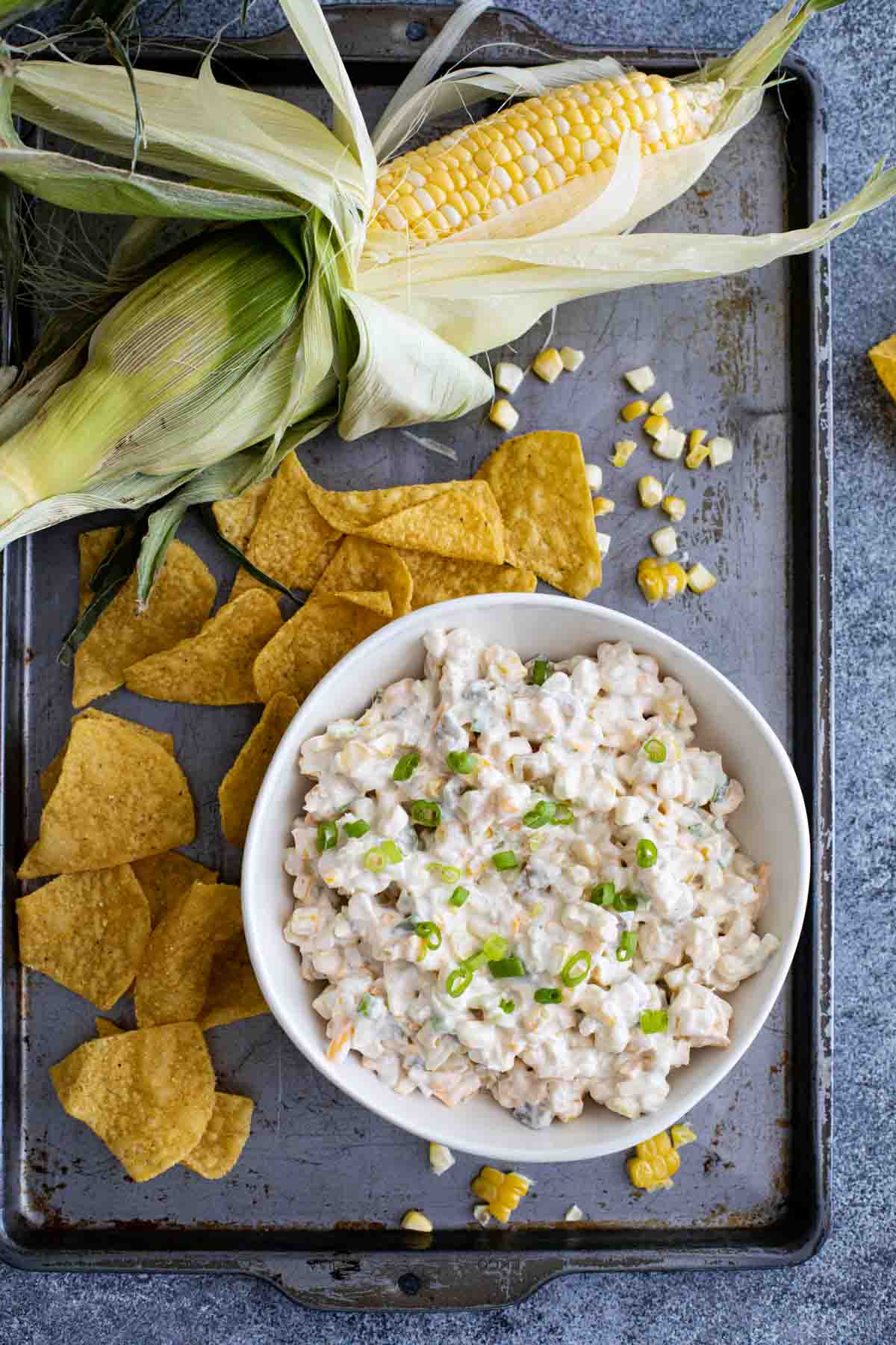 easy party corn dip on a baking sheet with corn chips and fresh corn