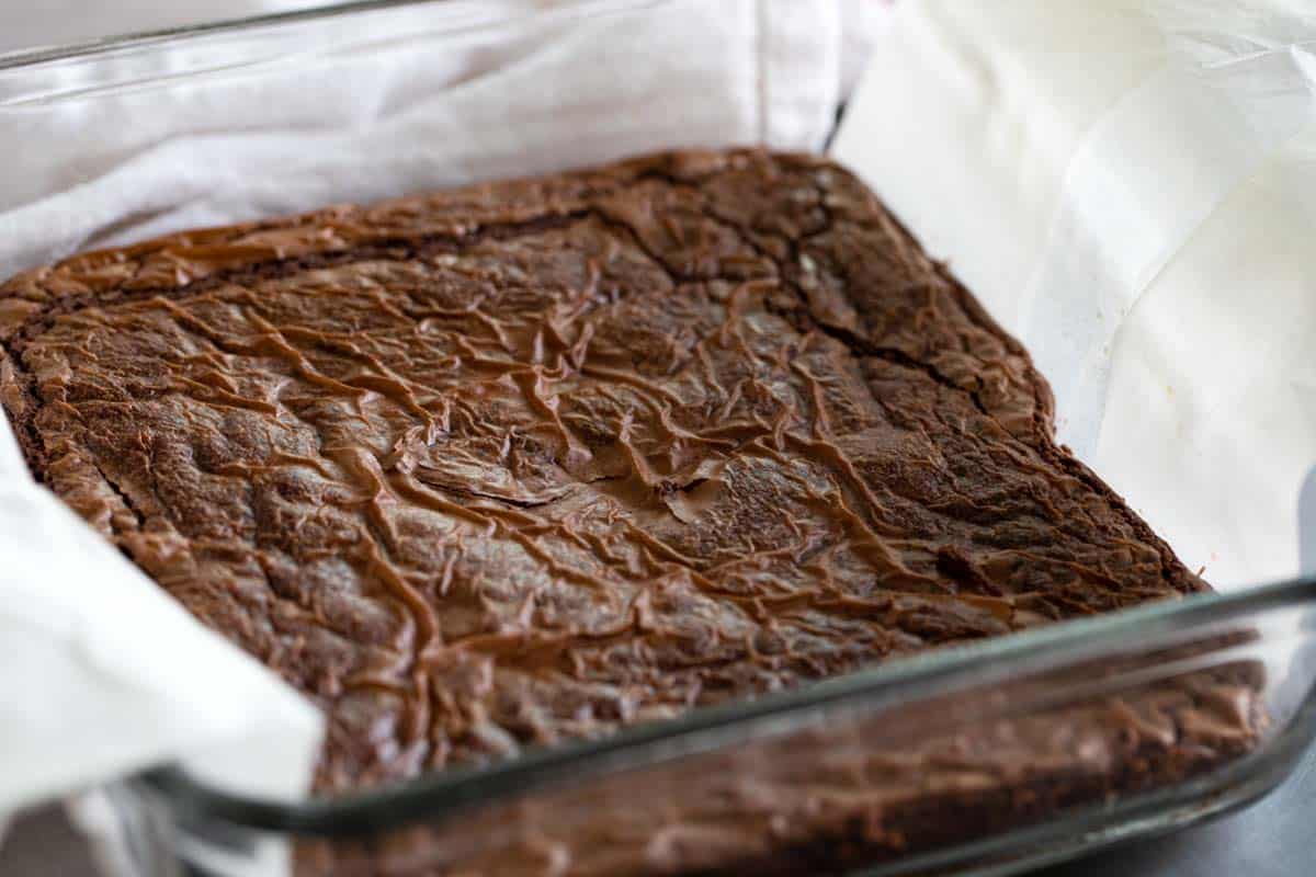 Baking dish with parchment paper and baked Nutella brownies.