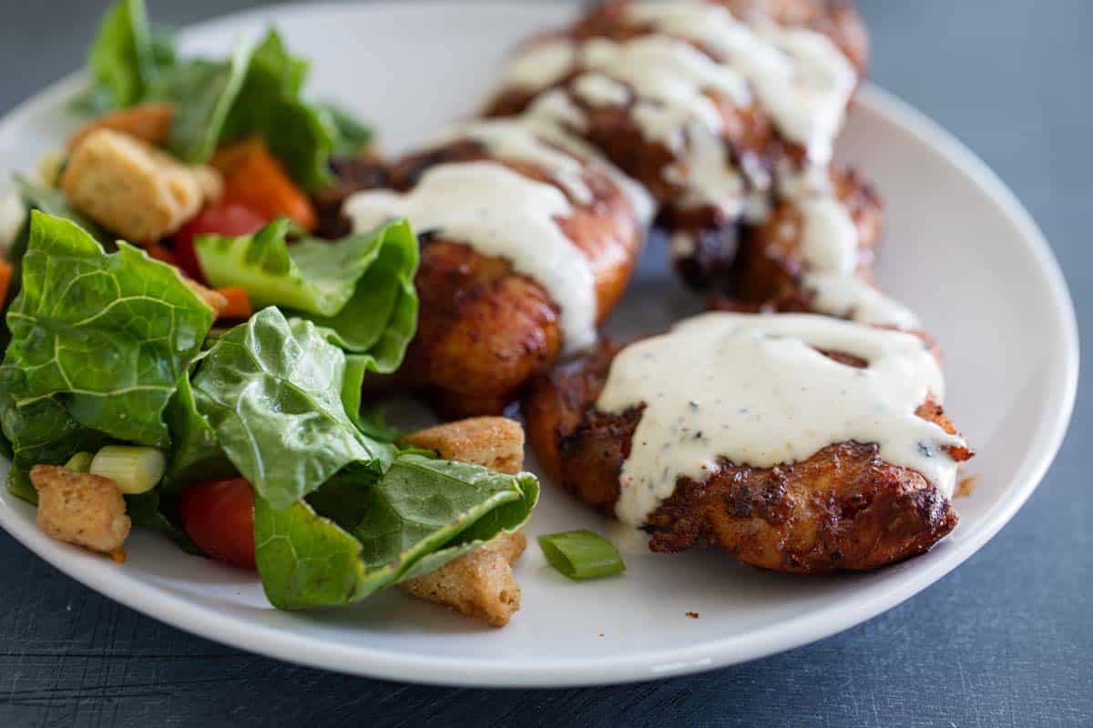 Chicken topped with white bbq sauce.