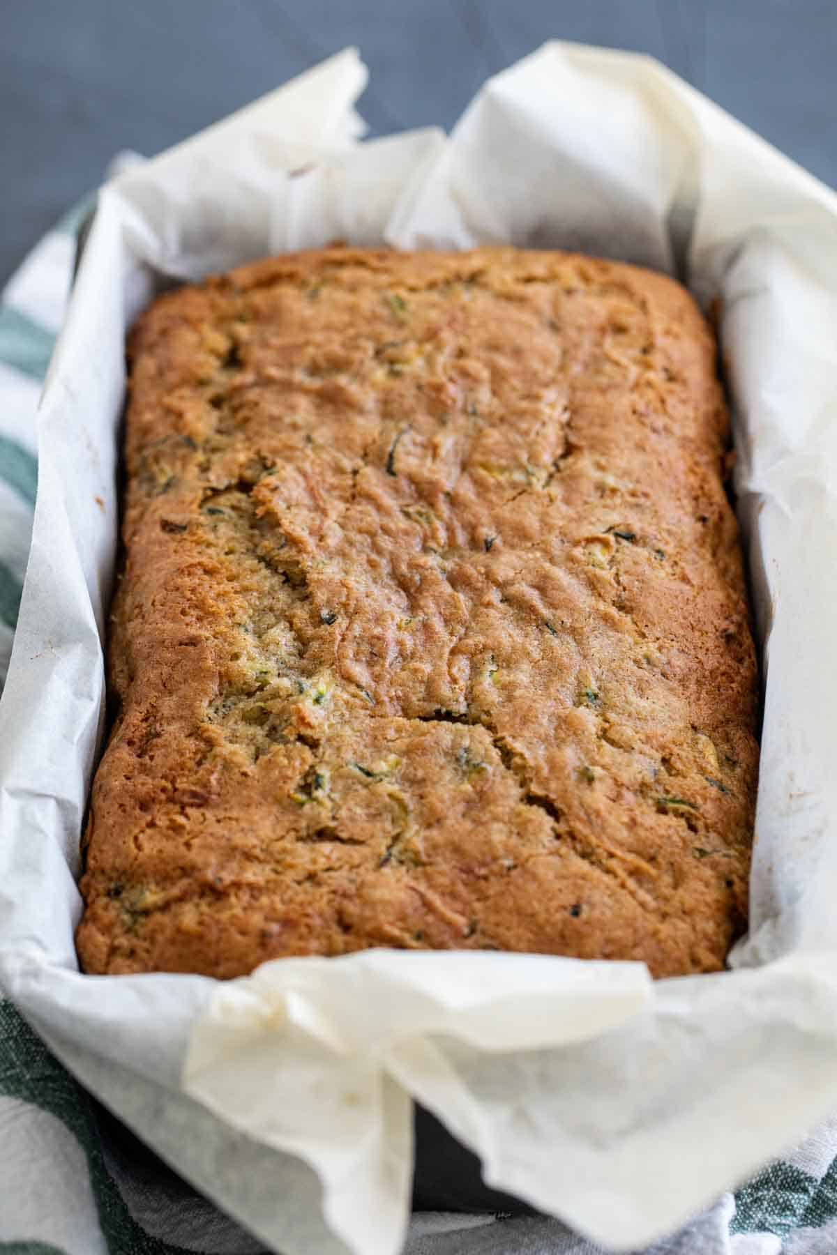 loaf of baked zucchini bread in a loaf pan