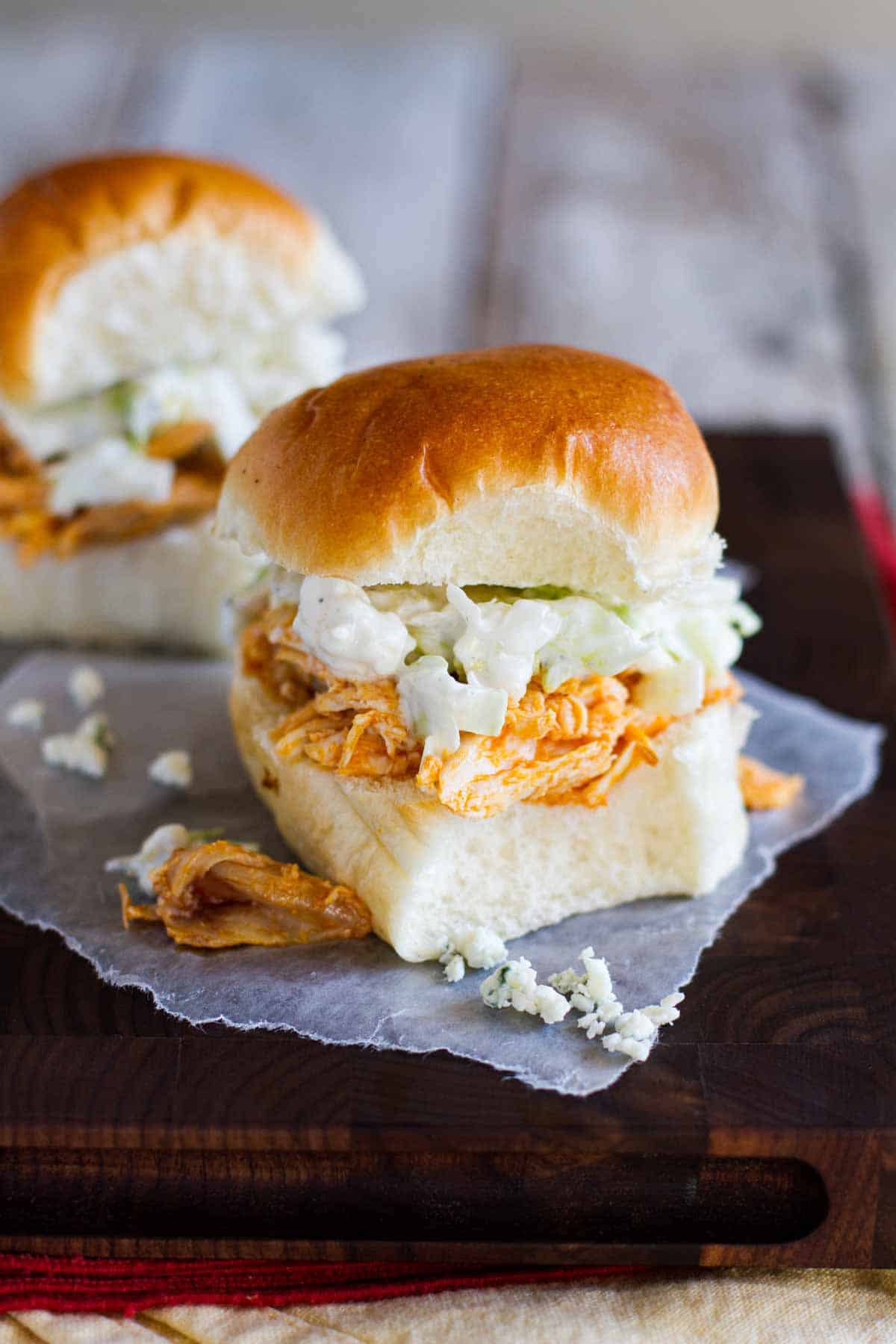 Perfect for game night, these Buffalo Chicken Sandwiches are piled with buffalo chicken and a blue cheese salad. Buffalo Chicken Sandwiches made on slider buns.