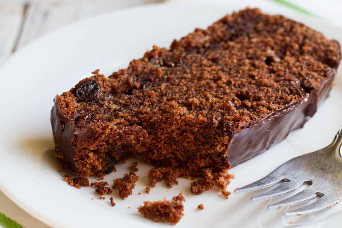 Slice of chocolate pound cake with a bite taken from it.