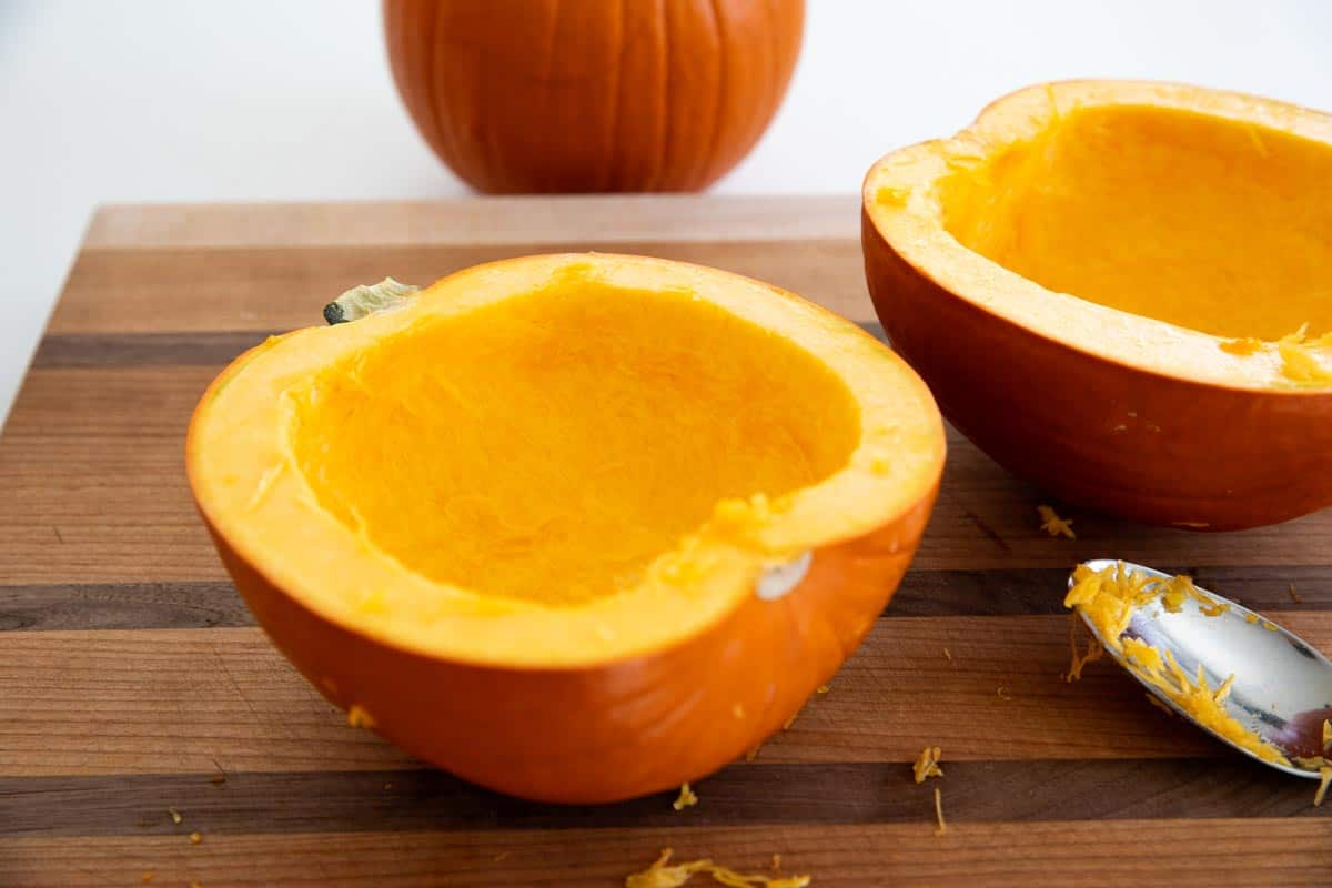 Scooping seeds from pumpkin to make pumpkin puree