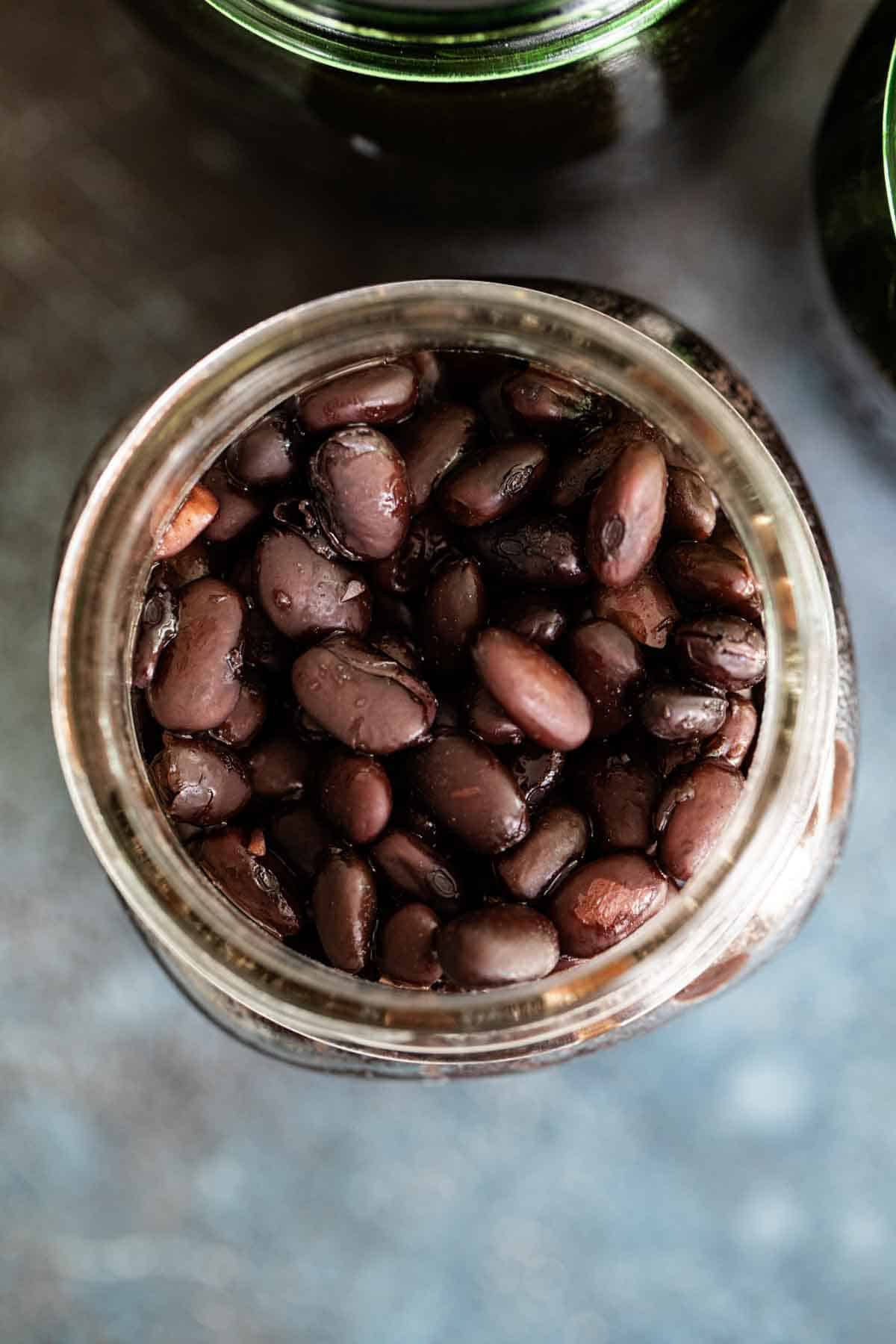 Homemade Slow Cooker Black Beans in mason jars for storage.
