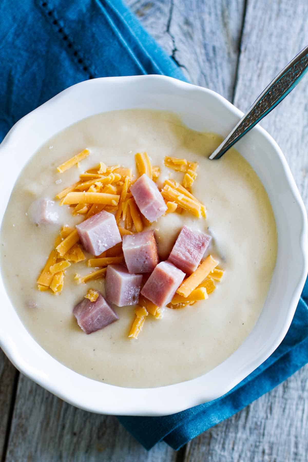 creamy cauliflower soup topped with ham and cheese