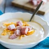bowl of cauliflower soup topped with ham and cheese