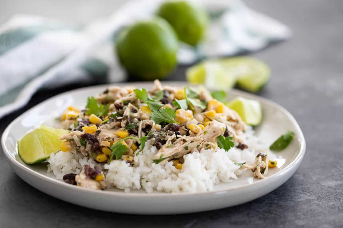 Slow Cooker Cilantro Lime Chicken Recipe served over rice with lime slices.