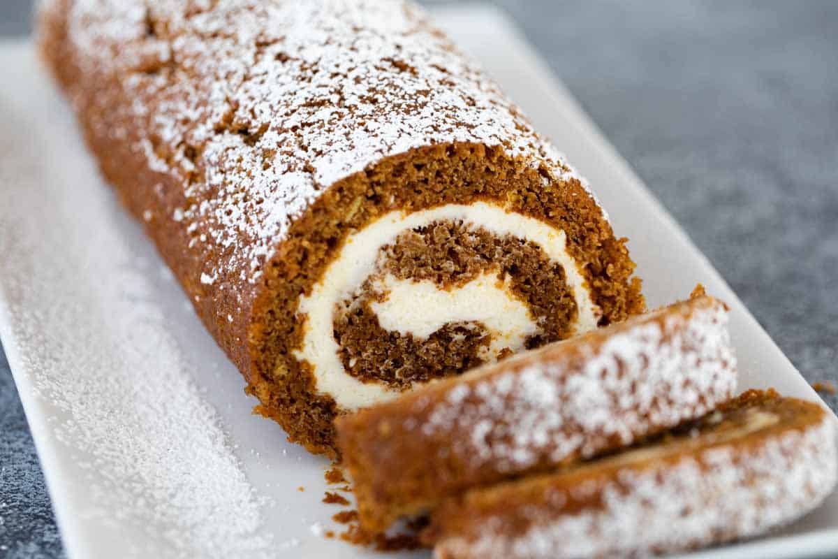 sliced pumpkin roll sprinkled with powdered sugar