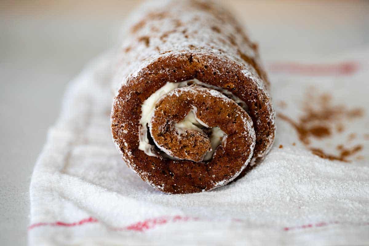 Rolled pumpkin cake roll on a tea towel