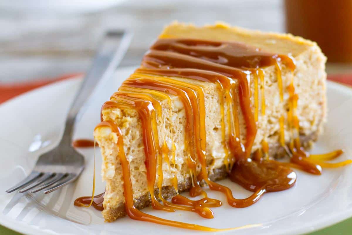 slice of pumpkin cheesecake topped with caramel sauce