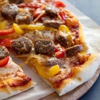 slice of pizza with sausage and peppers