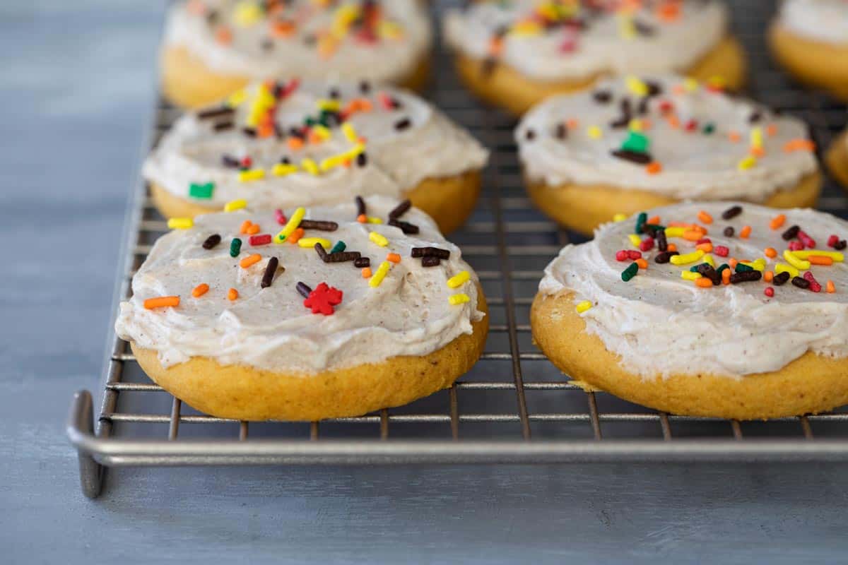 soft sugar cookies with pumpkin topped with maple cinnamon buttercream and sprinkles