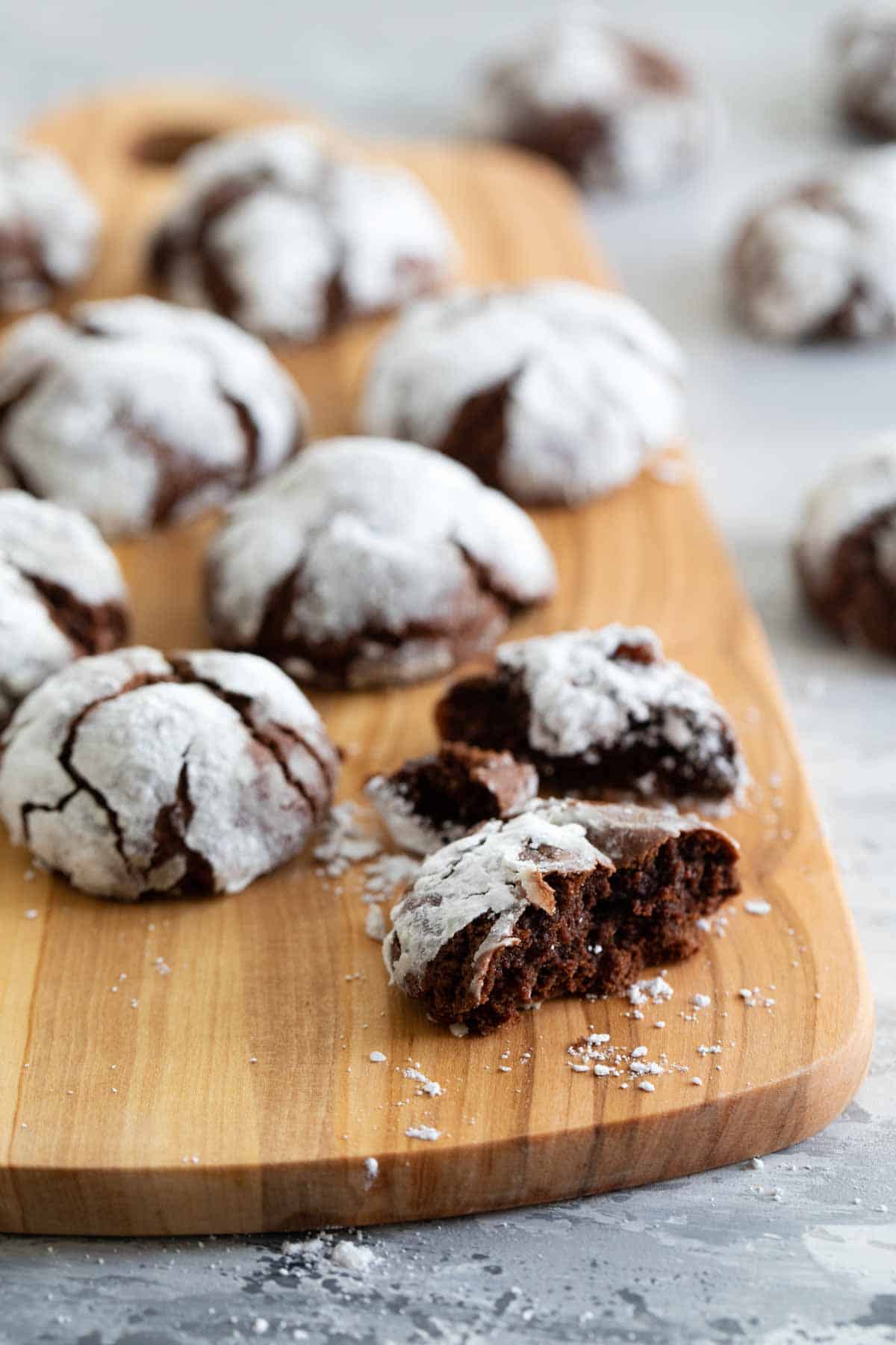 cutting board with chocolate crinkle cookies.