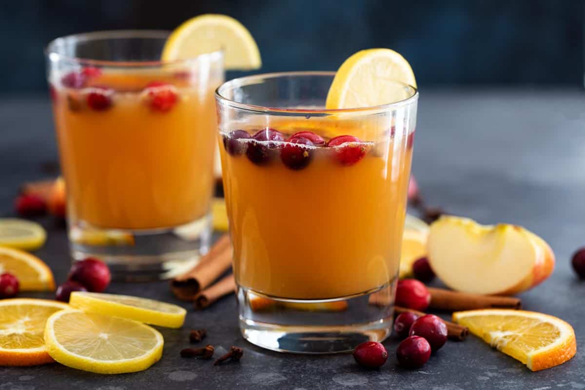 Hot Apple Cider in Glasses with apple slices and orange slices.