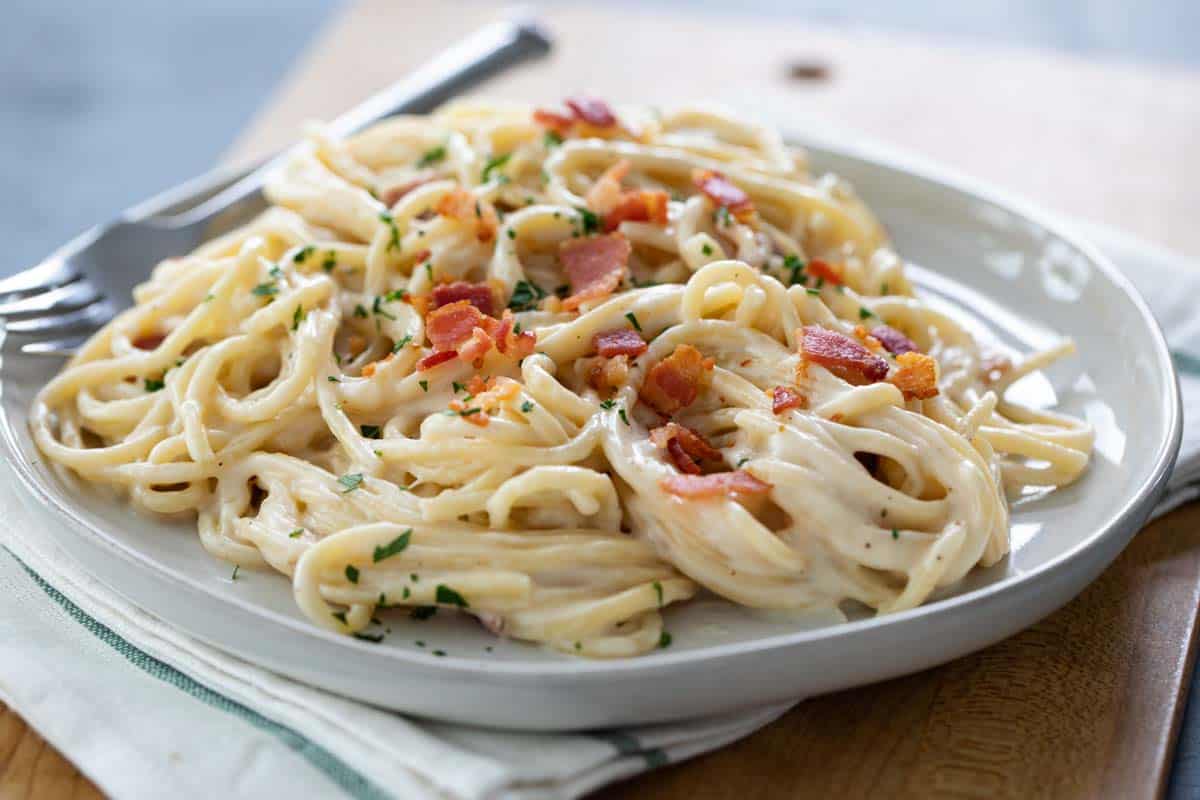 A decadent dinner recipe, this Alfredo Pasta with Bacon would be the perfect meal for a special night in. It tastes as good as eating out! Plate of Alfredo Pasta with Bacon