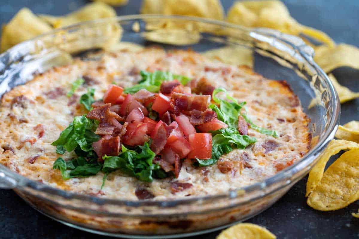 Easy Baked BLT Dip topped with lettuce and tomatoes