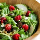 Raspberry Spinach Salad with Raspberry Vinaigrette in a wooden bowl.