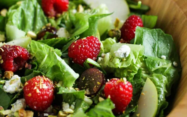 Raspberry Spinach Salad with Raspberry Vinaigrette in a wooden bowl.