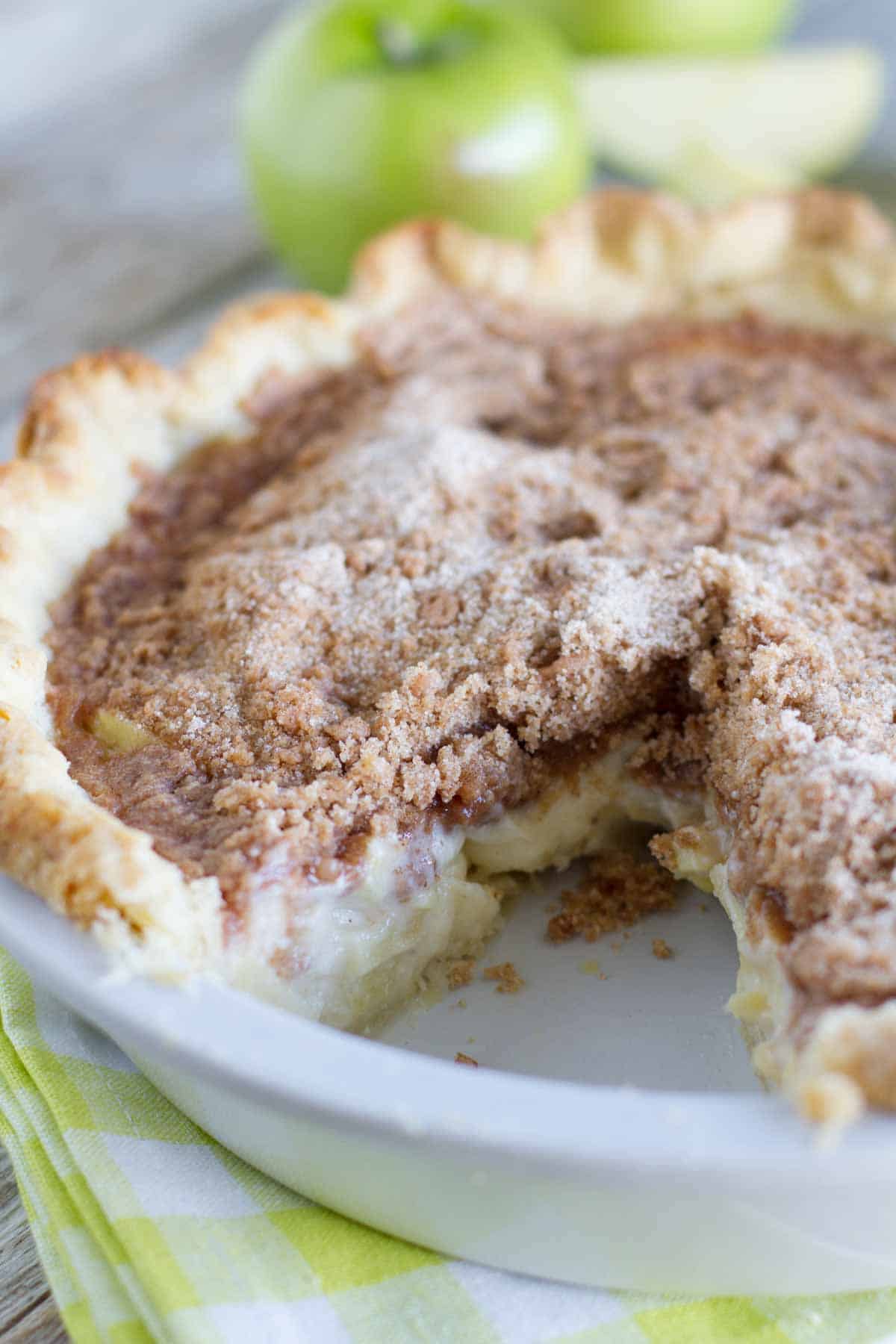 Apples are combined with a spiced sour cream mixture, then topped with lots of crumbly streusel in this favorite sour cream apple pie recipe. Sour Cream Apple Pie with Slice Gone