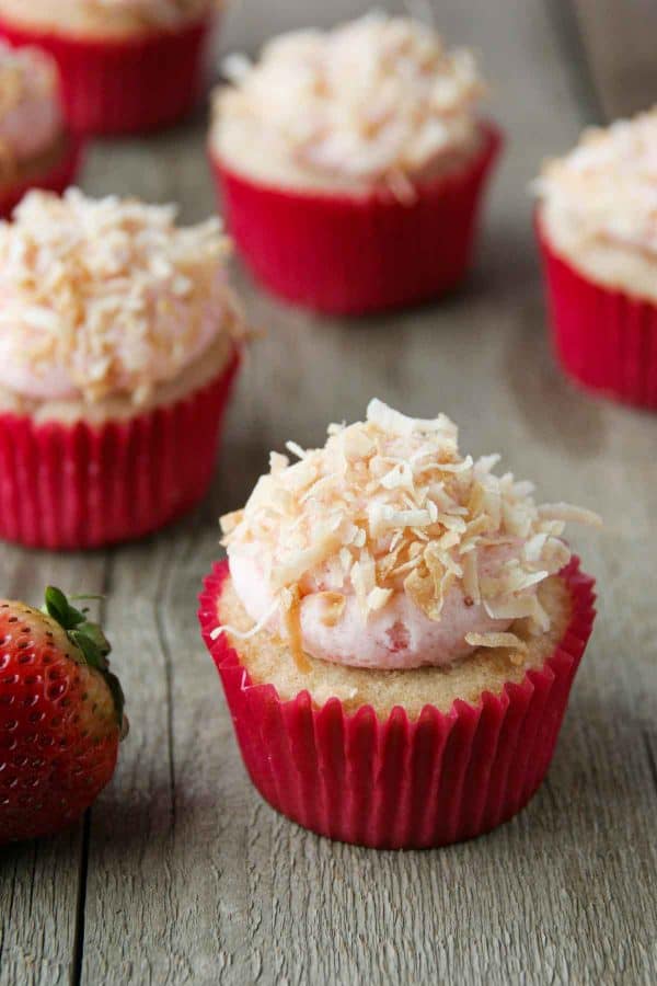 Strawberry, coconut and pineapple cupcakes topped with coconut frosting and toasted coconut