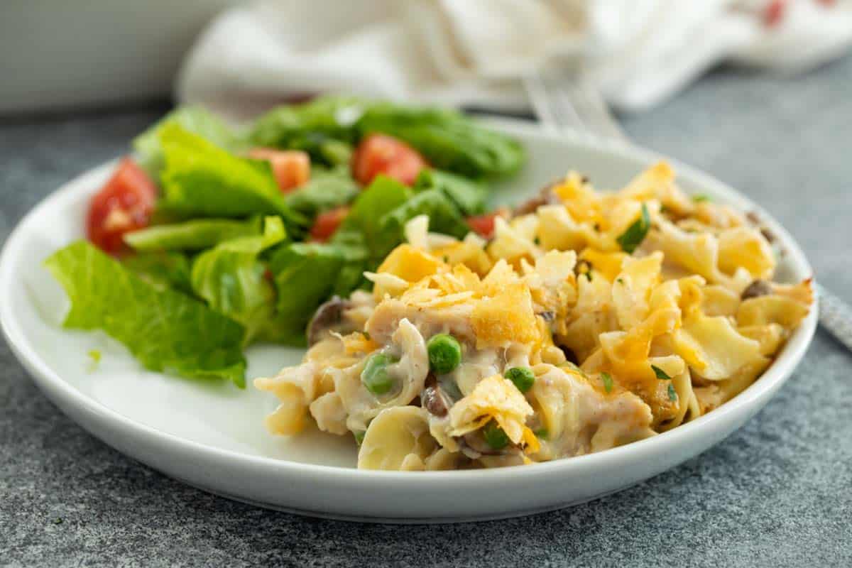 A childhood classic that should be in every recipe repertoire, this Tuna Casserole is nostalgic and comforting and creamy and delicious. It’s always a family favorite for a reason! Plate with Tuna Casserole and Salad