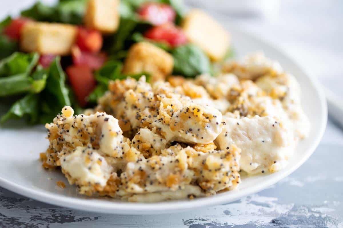 poppy seed chicken casserole on a plate with a side salad