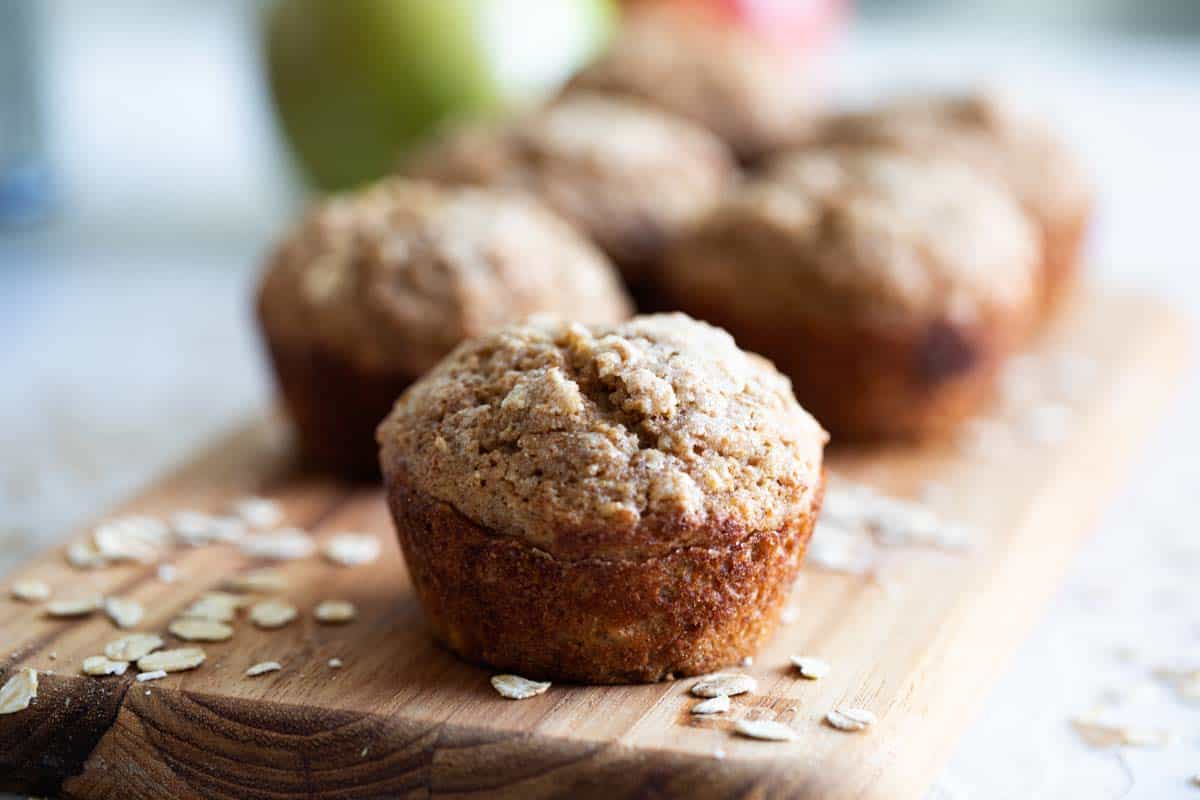 A healthy-ish breakfast recipe, these Oatmeal Muffins with Applesauce are filling and flavorful and perfect for breakfast on the go. Muffins made with oats and applesauce on a cutting board