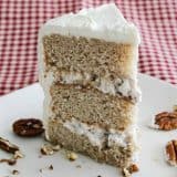 slice of banana cake on a plate with pecans