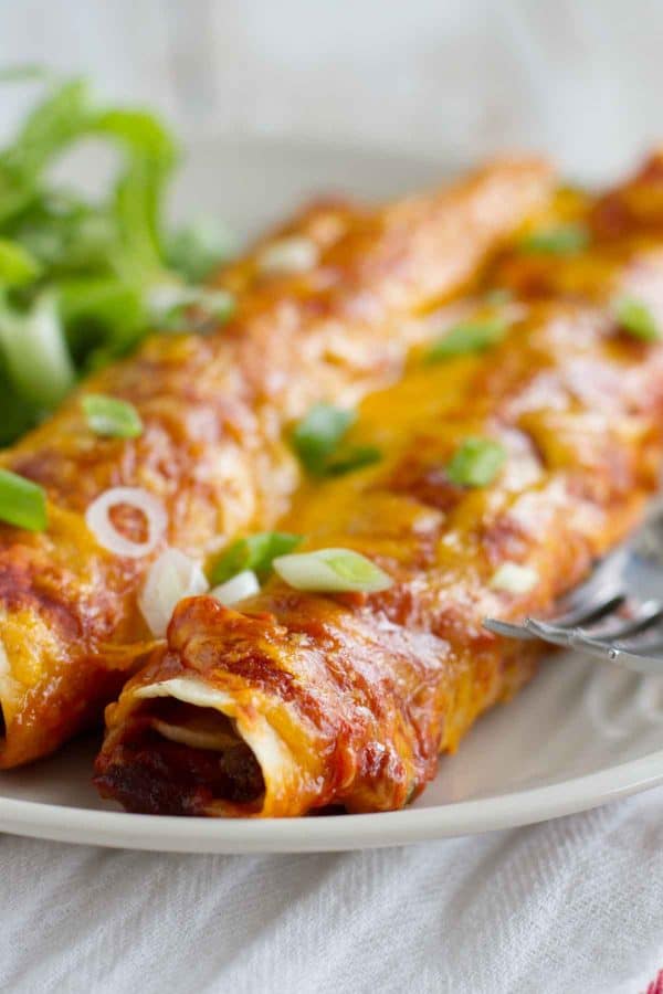 beef and bean enchiladas topped with red enchilada sauce