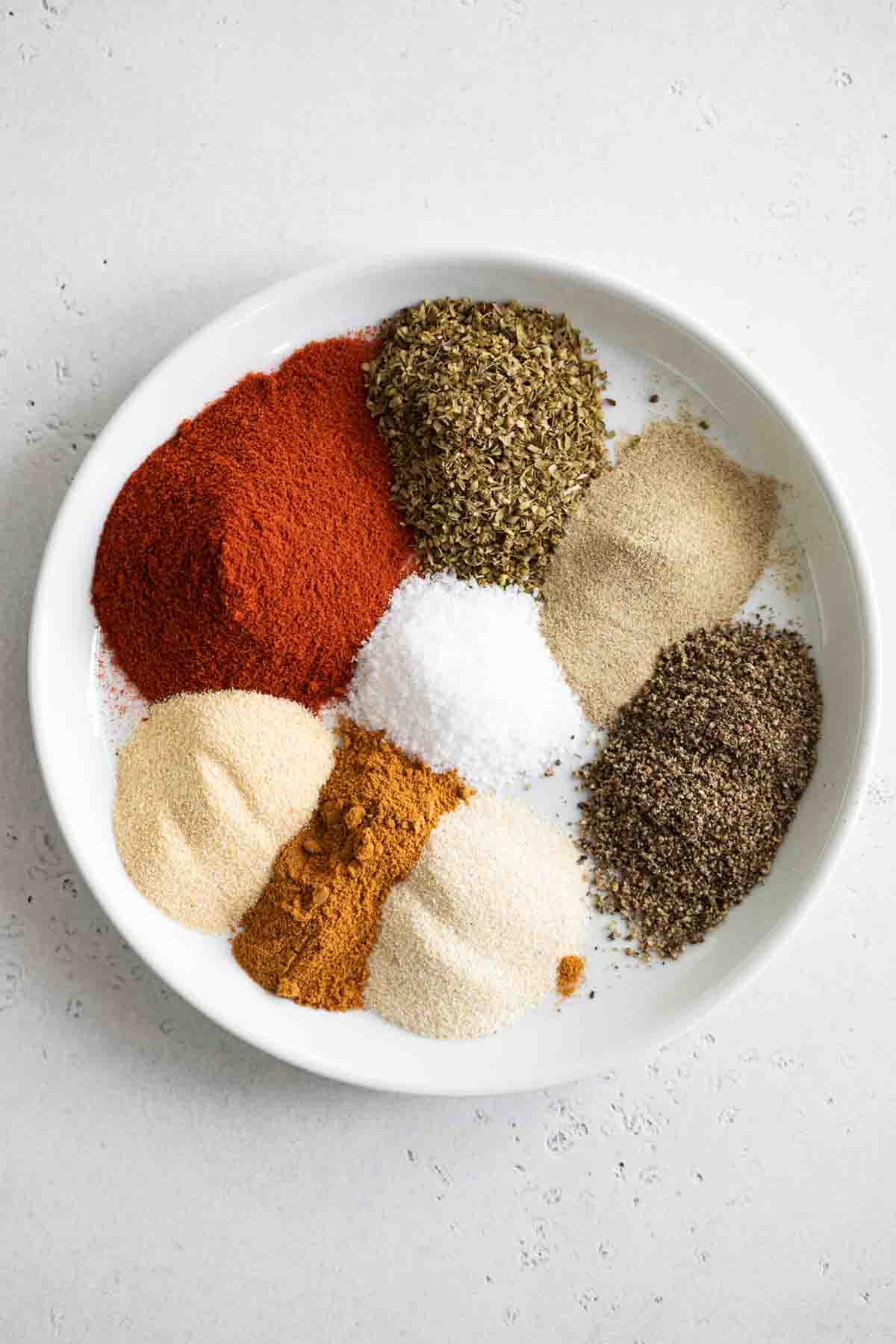 piles of spices needed to make homemade cajun seasoning