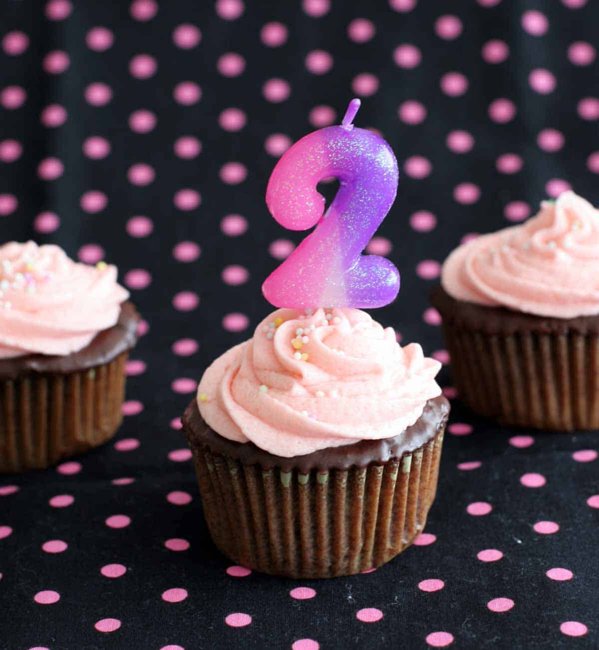 Chocolate cupcakes with buttercream and a number 2 candle
