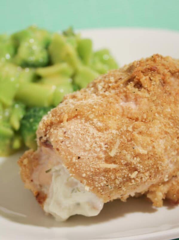 cheese stuffed chicken on a plate with broccoli