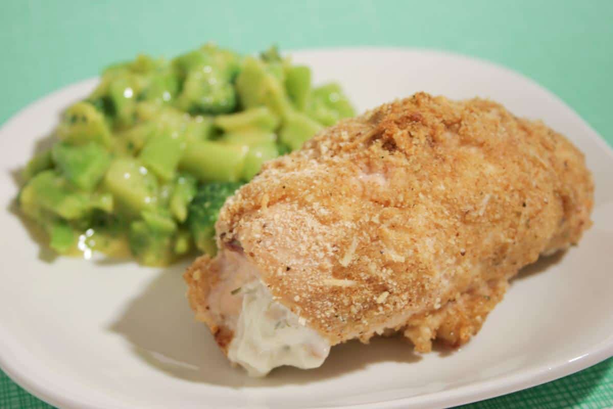 cheese stuffed chicken on a plate with broccoli