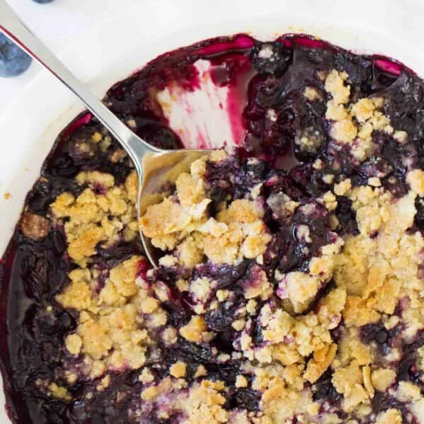 Dish of blueberry crisp with serving spoon